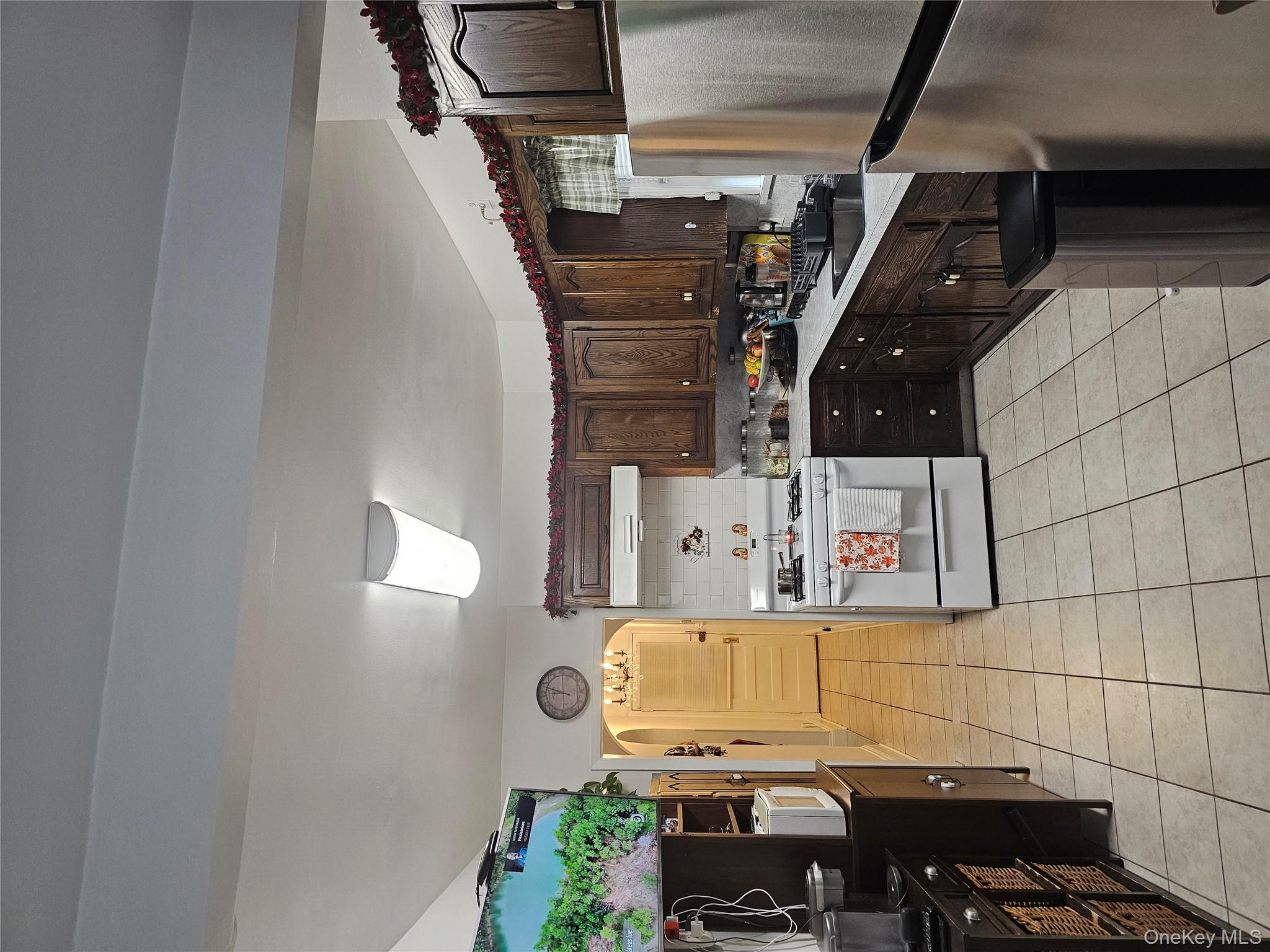 232 Doughty Boulevard Inwood, NY 11096 - Photo 5 of 11 a kitchen with a refrigerator a stove top oven and a sink