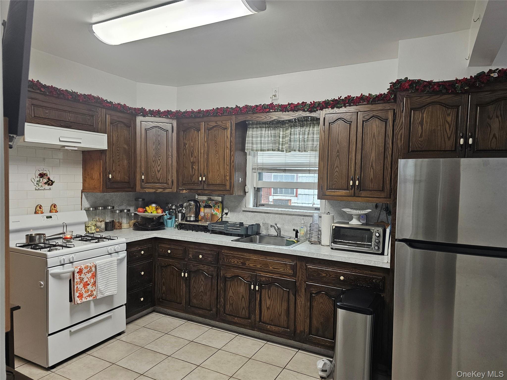 232 Doughty Boulevard Inwood, NY 11096 - Photo 6 of 11 a kitchen with a sink stove and refrigerator