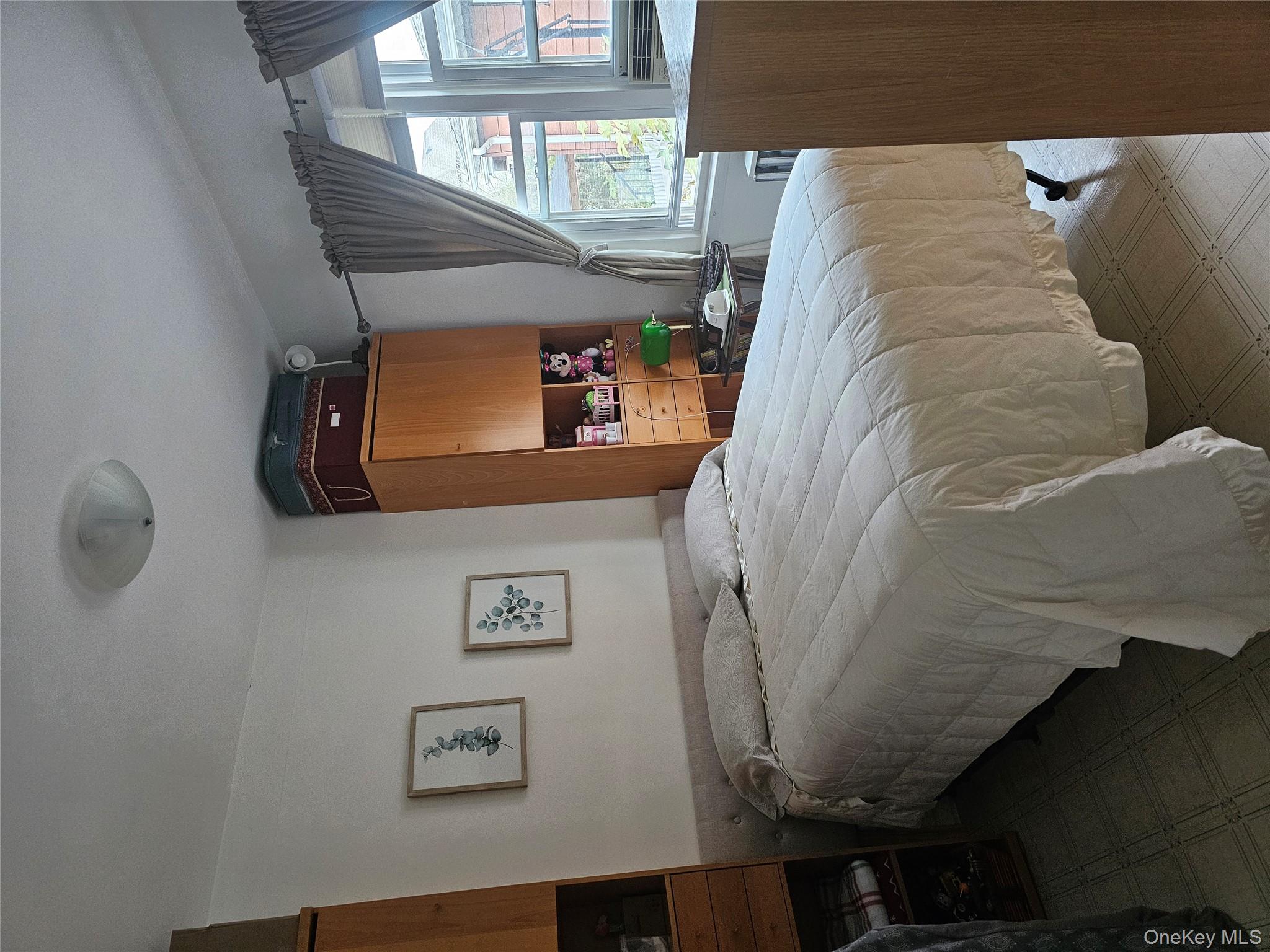 232 Doughty Boulevard Inwood, NY 11096 - Photo 8 of 11 a bedroom with a bed large mirror and window