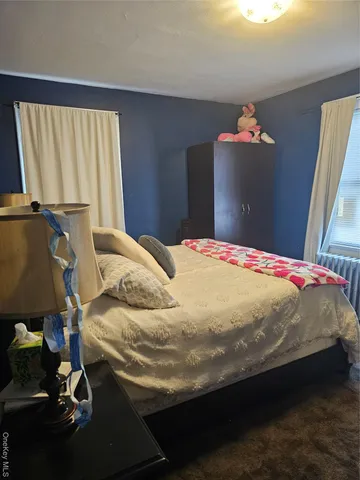 a bed sitting in a bedroom next to a window