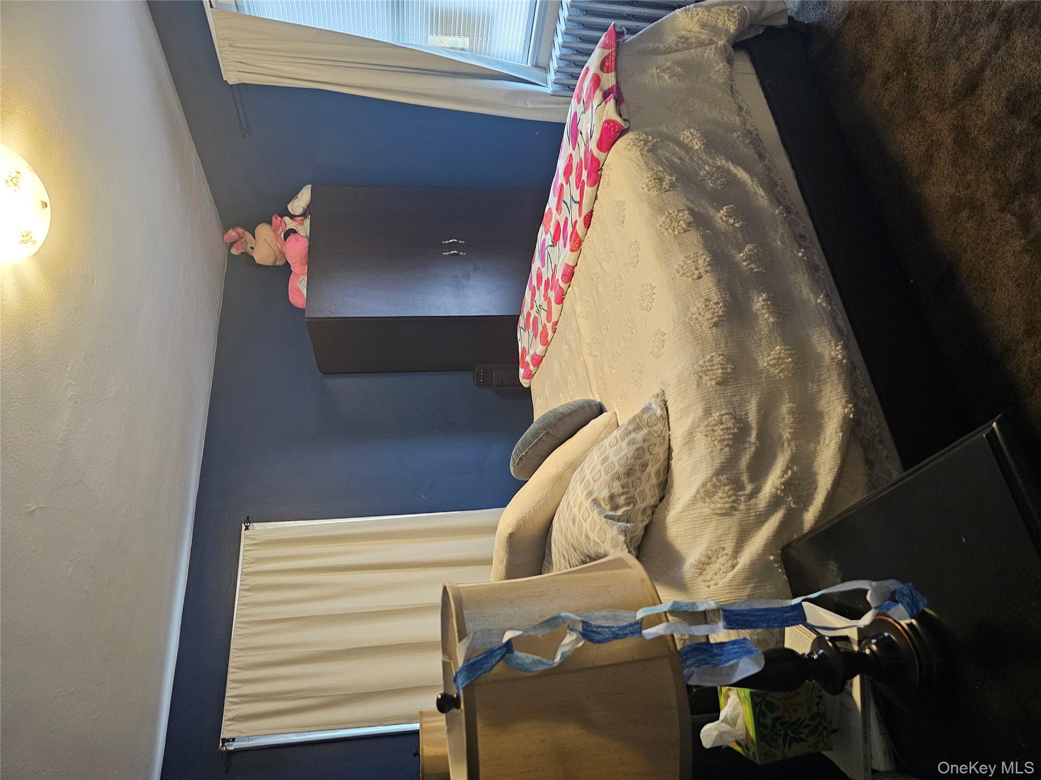 232 Doughty Boulevard Inwood, NY 11096 - Photo 10 of 11 a bed sitting in a bedroom next to a window