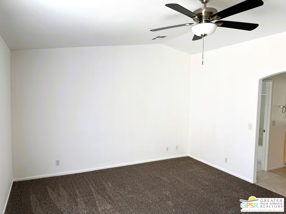 9700 Santa Cruz Road Desert Hot Springs, CA 92240 - Photo 22 of 37 an empty room with a ceiling fan and a window