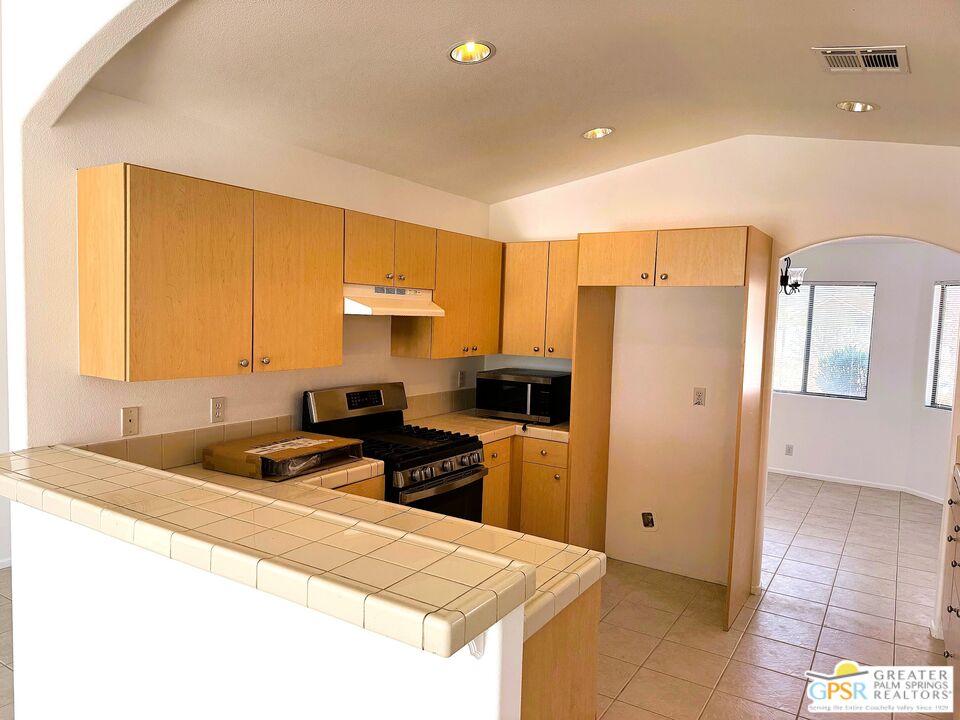 9700 Santa Cruz Road Desert Hot Springs, CA 92240 - Photo 4 of 37 a kitchen with a refrigerator a stove a sink and a cabinets