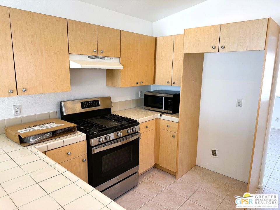 9700 Santa Cruz Road Desert Hot Springs, CA 92240 - Photo 5 of 37 a kitchen with stainless steel appliances granite countertop a stove a refrigerator and a refrigerator