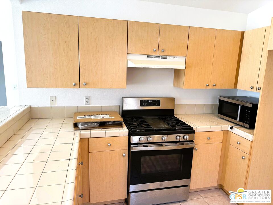 9700 Santa Cruz Road Desert Hot Springs, CA 92240 - Photo 6 of 37 a kitchen with a stove and a microwave
