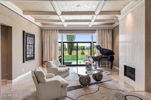 a living room with furniture a fireplace and a floor to ceiling window