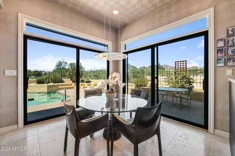 a dining room with furniture large windows and wooden floor