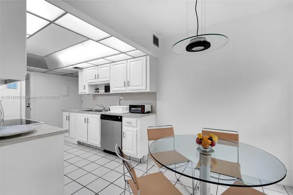 a kitchen with stainless steel appliances granite countertop a sink and white cabinets