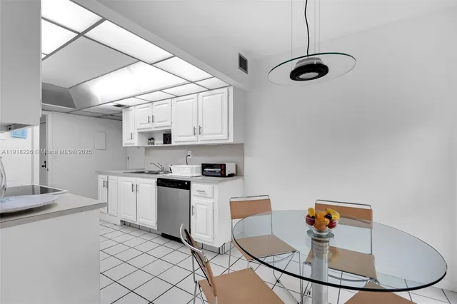 a kitchen with stainless steel appliances granite countertop a sink and white cabinets