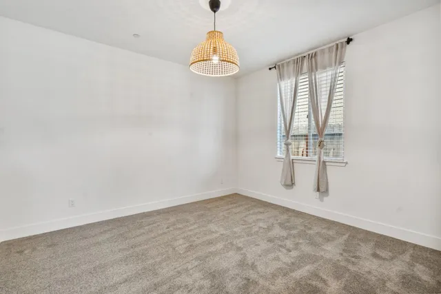 an empty room with windows and chandelier