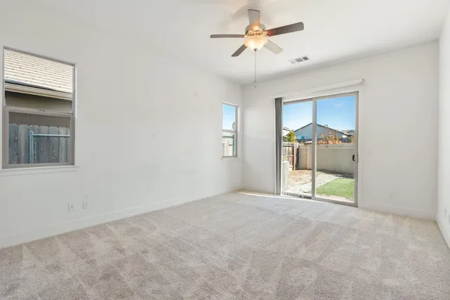 an empty room with fan and windows