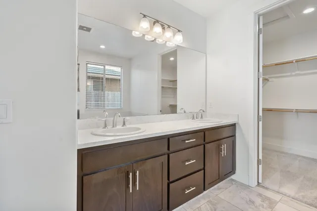 a bathroom with a double vanity sink and a mirror