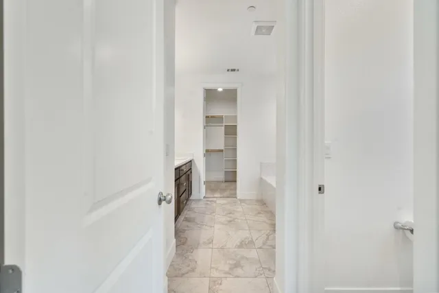 a view of a hallway with a white cabinet and a refrigerator