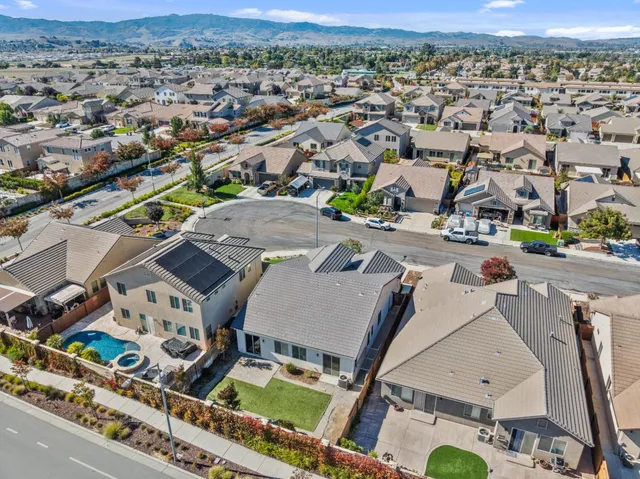 an aerial view of residential houses with outdoor space and parking