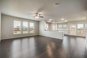 817 Paper Daisy Path Leander, TX 78641 - Photo 12 of 12 An open floorplan living area flows seamlessly into the kitchen, illuminated by abundant windows.