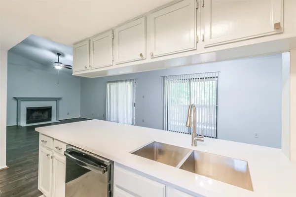 a kitchen with granite countertop a sink and dishwasher a stove with white countertops