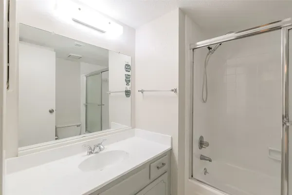 a bathroom with a shower sink vanity and mirror
