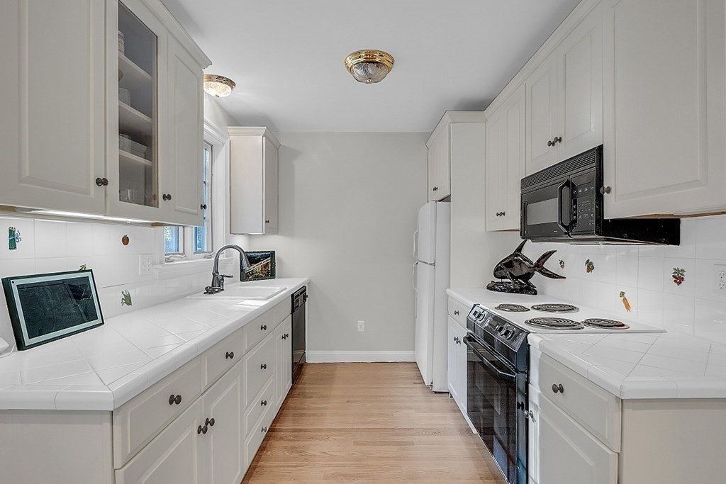 117 Channing Road Concord, MA 01742 - Photo 20 of 38 a kitchen with stainless steel appliances a white stove top oven a sink a refrigerator and white cabinets