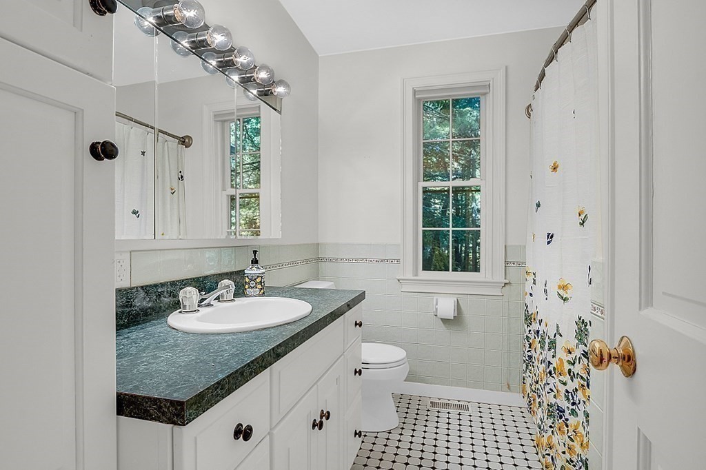 117 Channing Road Concord, MA 01742 - Photo 23 of 38 a bathroom with a granite countertop sink a mirror a and a shower
