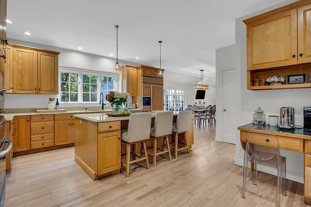 117 Channing Road Concord, MA 01742 - Photo 8 of 38 a kitchen with stainless steel appliances granite countertop a stove a sink dishwasher a dining table and chairs with wooden floor
