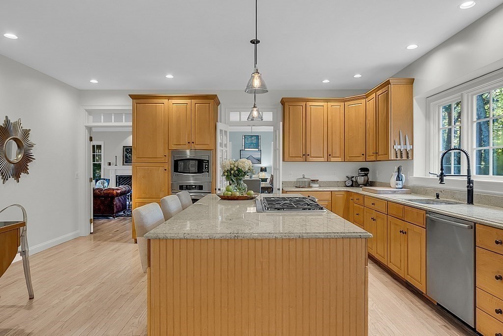 117 Channing Road Concord, MA 01742 - Photo 9 of 38 a kitchen with kitchen island granite countertop a sink cabinets and wooden floor