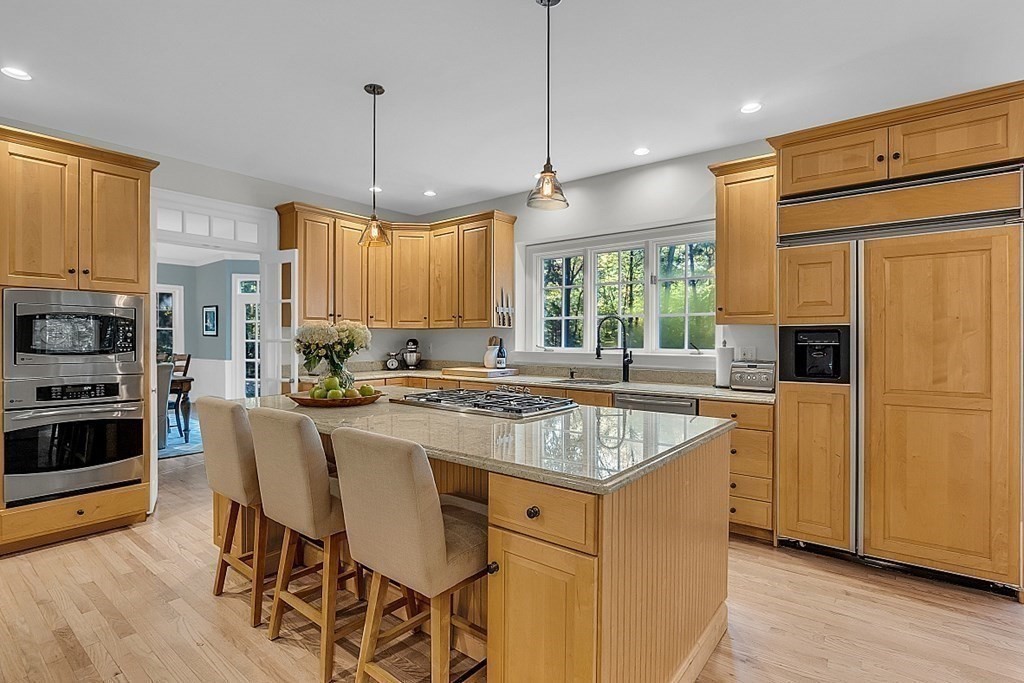 117 Channing Road Concord, MA 01742 - Photo 10 of 38 a kitchen with stainless steel appliances granite countertop a stove a sink a refrigerator a center island and a wooden floor