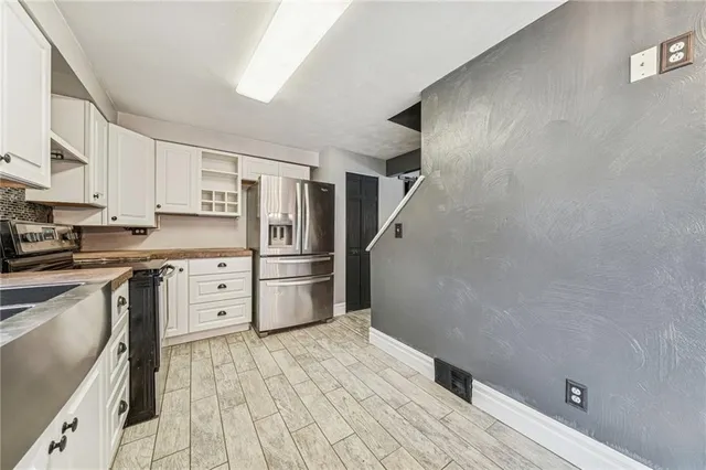 a kitchen with stainless steel appliances a refrigerator and cabinets