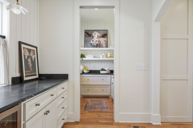 a kitchen with stainless steel appliances a stove a sink dishwasher and white cabinets with wooden floor