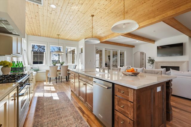 a kitchen with a dining table chairs and refrigerator