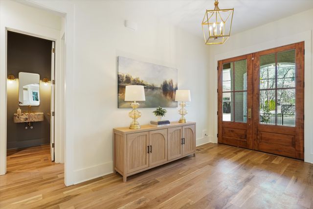 a dining room with furniture a chandelier and wooden floor