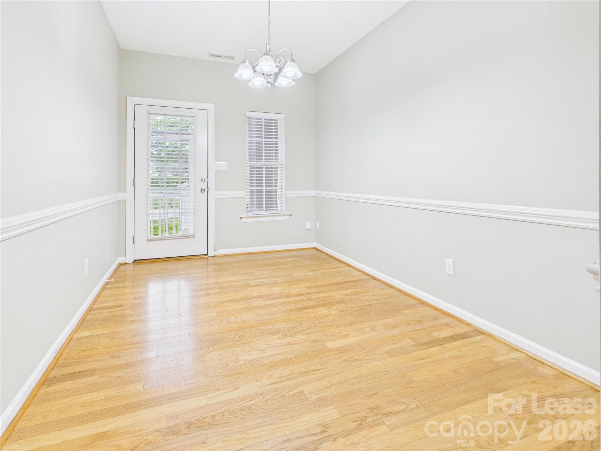 5690 Stafford Road Charlotte, NC 28215 - Photo 8 of 25 an empty room with wooden floor and windows