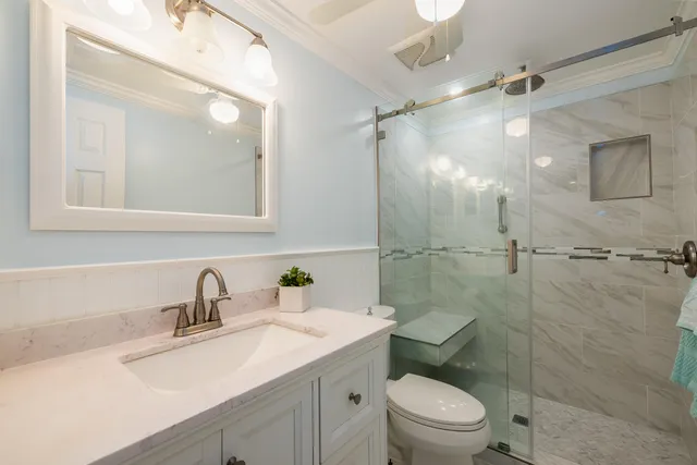 a bathroom with a sink toilet a mirror and shower