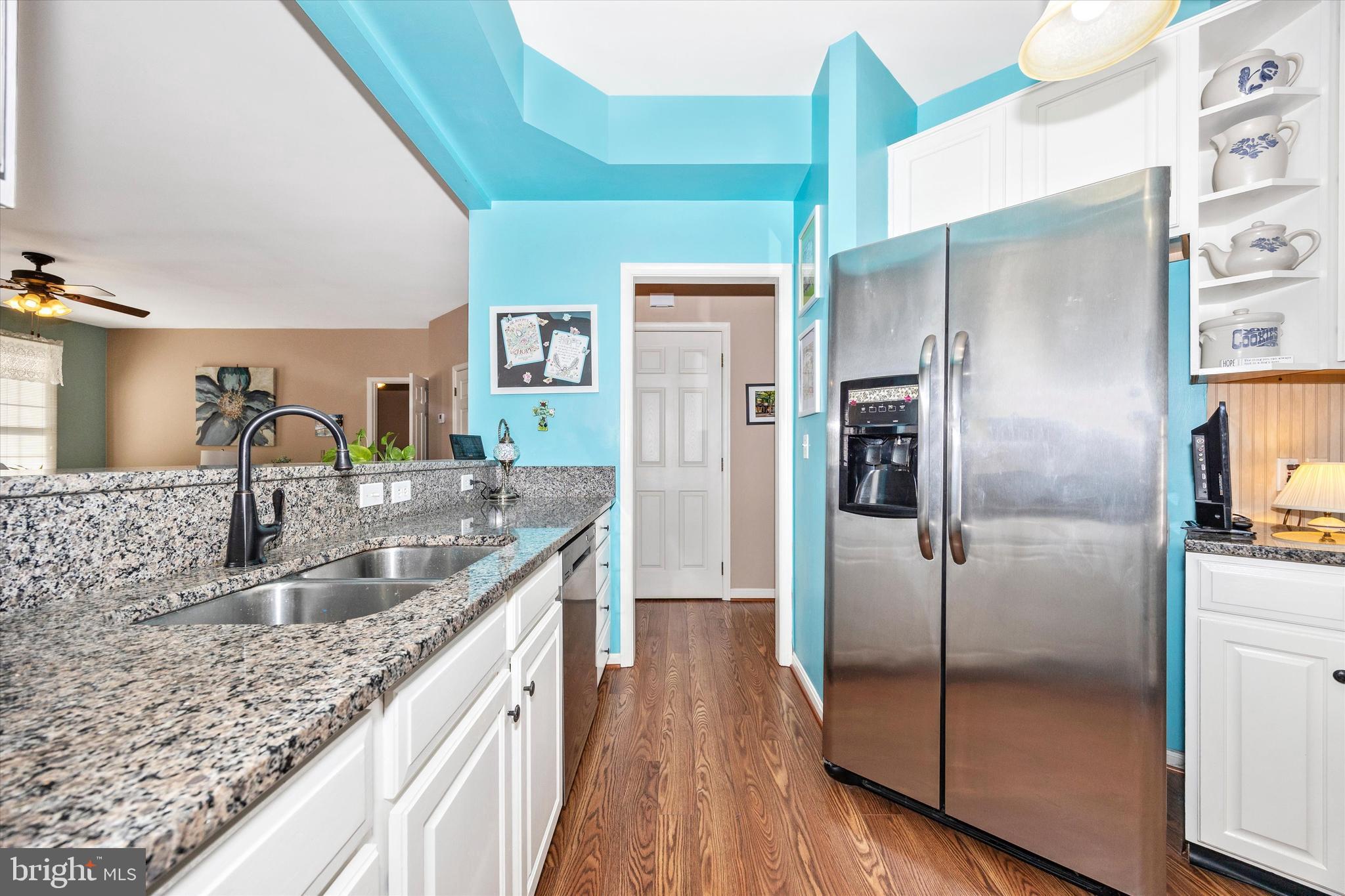 1005 Eastbourne Terrace Frederick, MD 21702 - Photo 12 of 39 a kitchen with kitchen island granite countertop a refrigerator a sink and wooden floor