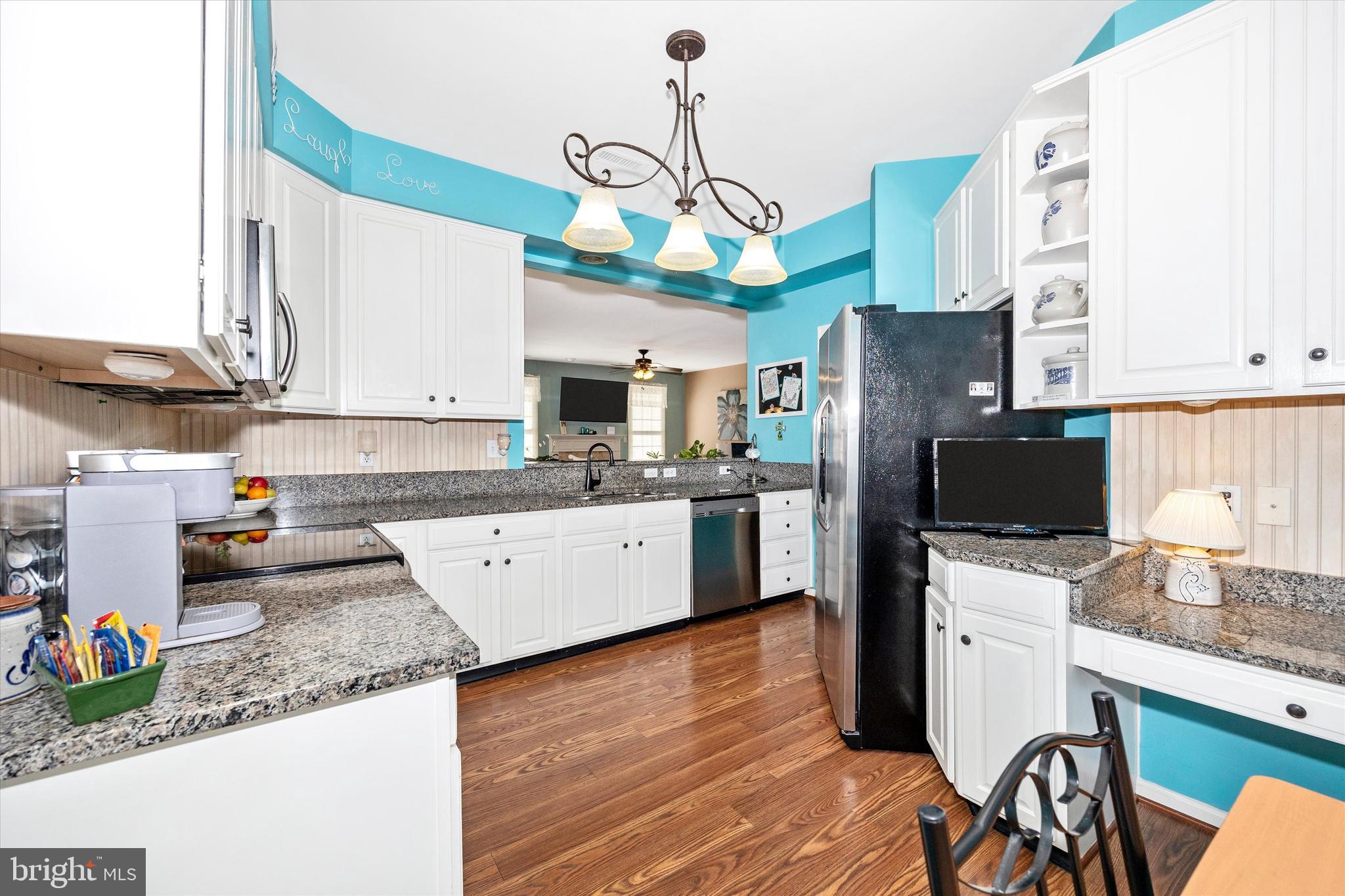 1005 Eastbourne Terrace Frederick, MD 21702 - Photo 13 of 39 a kitchen with stainless steel appliances granite countertop a refrigerator a stove a sink dishwasher and white cabinets with wooden floor