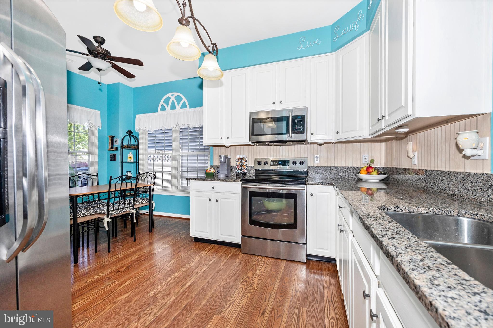 1005 Eastbourne Terrace Frederick, MD 21702 - Photo 10 of 39 a kitchen with stainless steel appliances granite countertop a stove top oven a sink dishwasher and a refrigerator with wooden floor