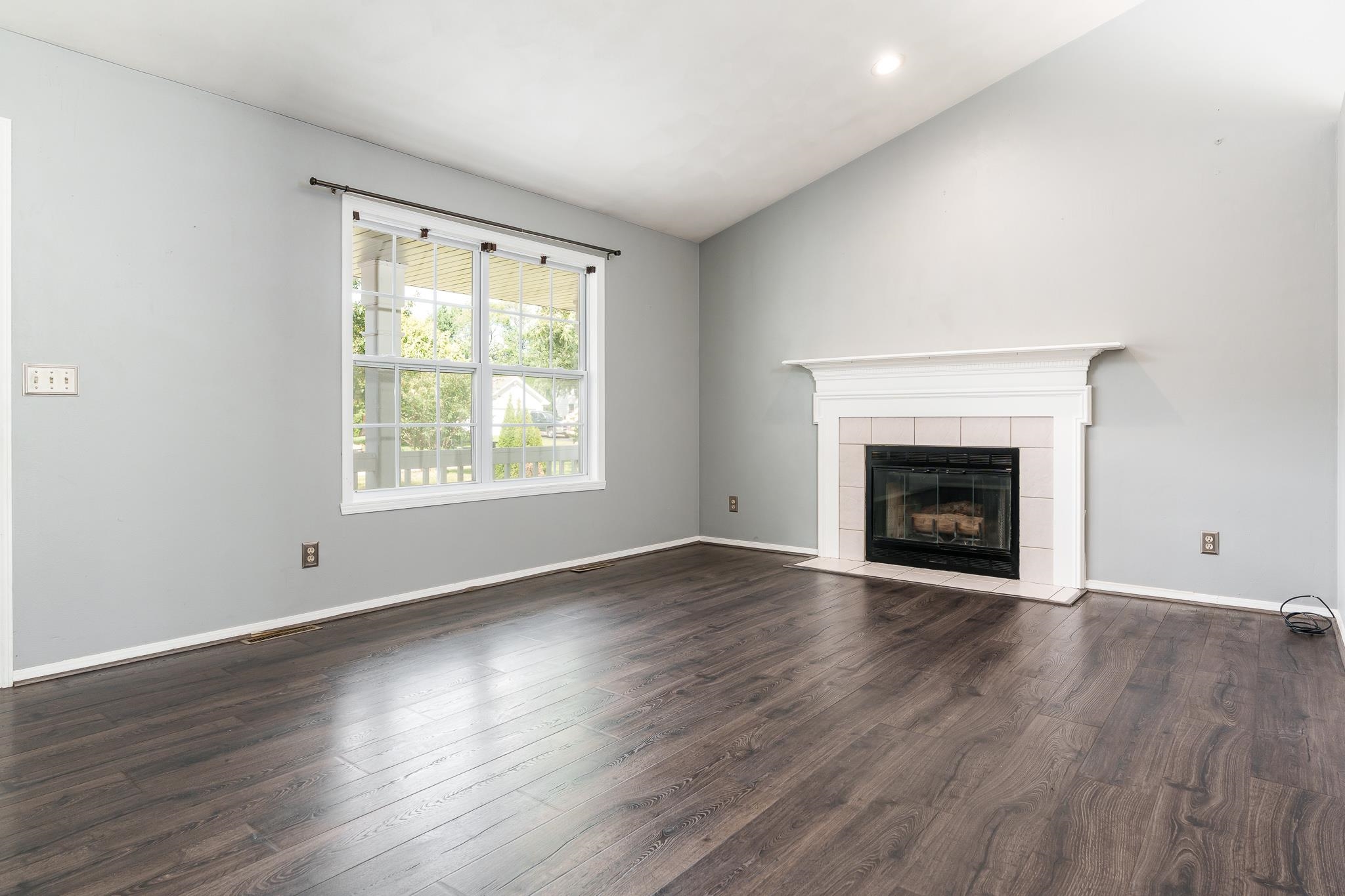 1996 Broadmoor Road Rockton, IL 61072 - Photo 14 of 45 an empty room with wooden floor fireplace and windows