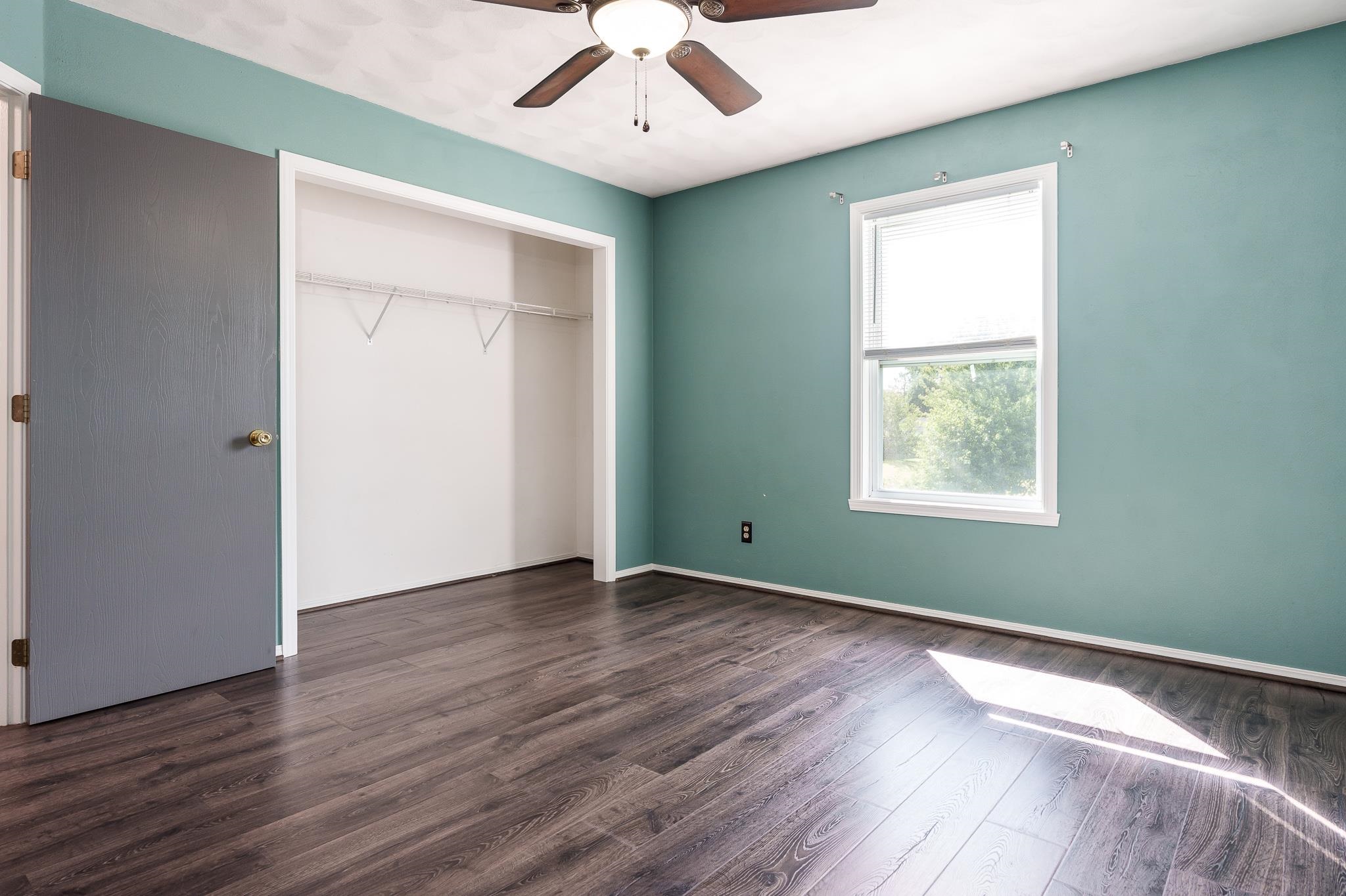 1996 Broadmoor Road Rockton, IL 61072 - Photo 27 of 45 an empty room with wooden floor chandelier fan and windows