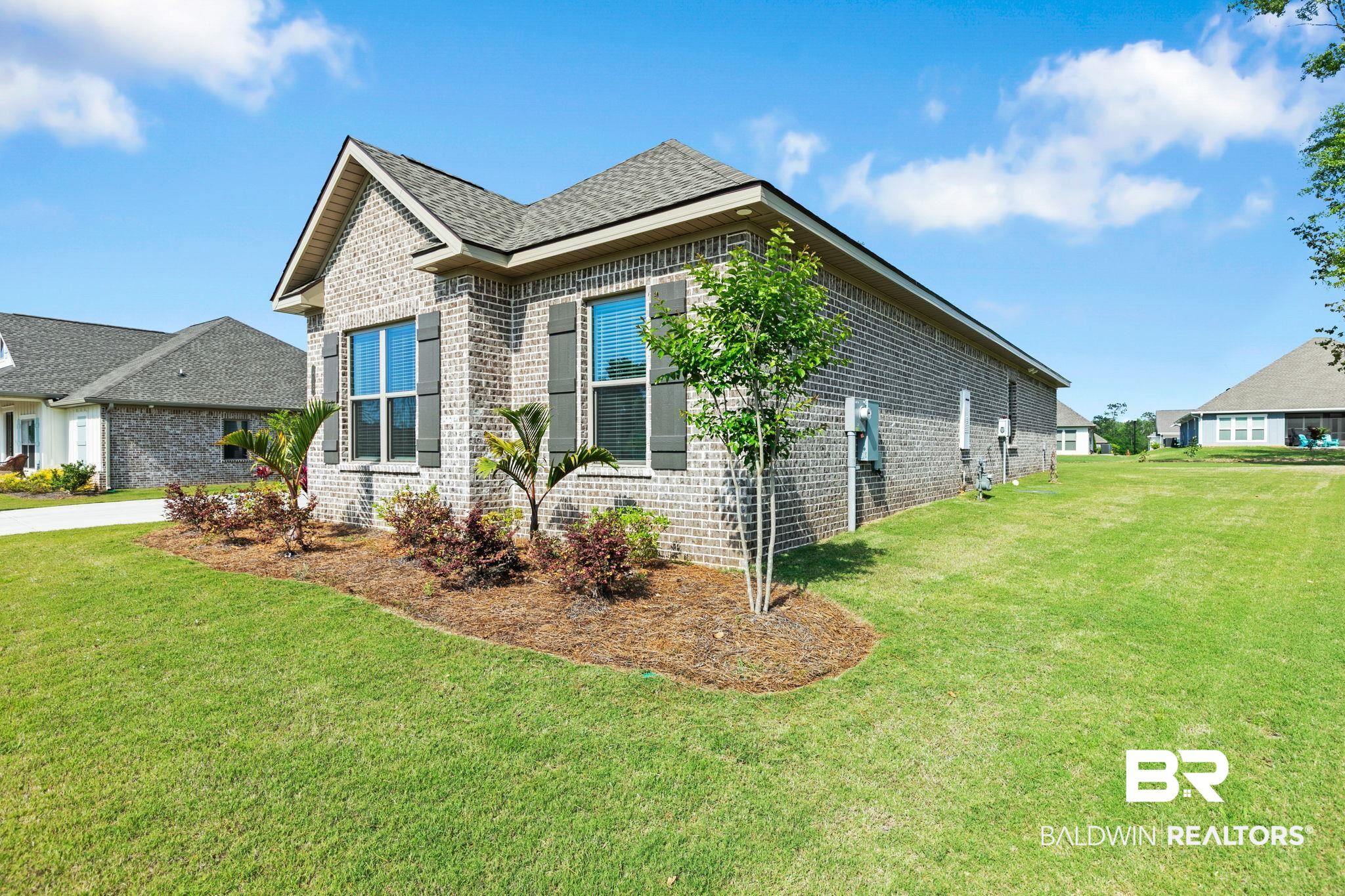 12132 Exbury Way Daphne, AL 36527 - Photo 4 of 47 View of home's exterior with brick siding and a yard