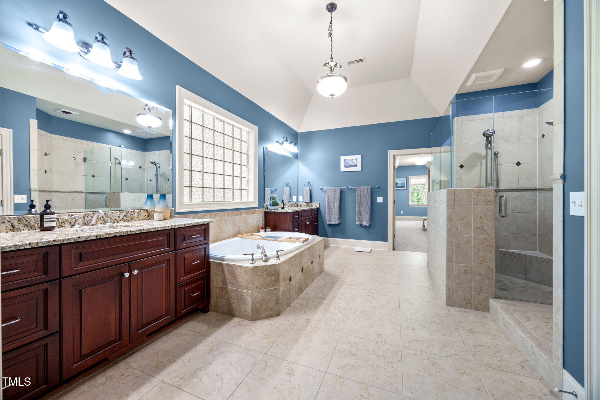 2409 Loring Court Raleigh, NC 27613 - Photo 25 of 60 a spacious bathroom with a bathtub shower sink mirror and toilet