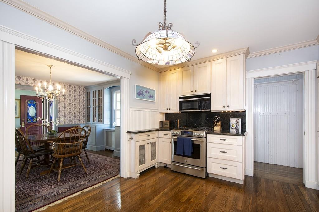 185 Downer Avenue Hingham, MA 02043 - Photo 22 of 30 a kitchen with kitchen island granite countertop a stove oven and white cabinets with wooden floor