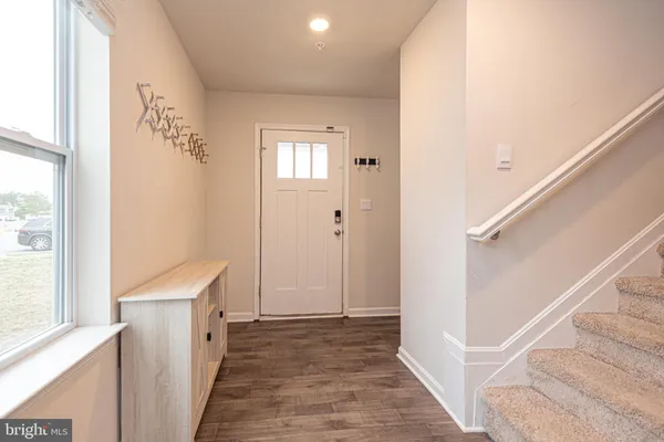 a view of a hallway with wooden floor and staircase