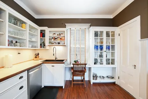a kitchen with stainless steel appliances a stove a refrigerator and wooden floors