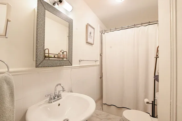 a bedroom with a large bed and a flat tv screen on dresser