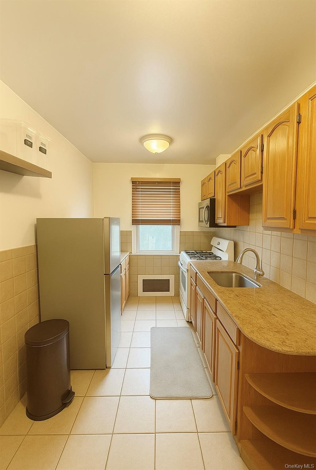 7103 252nd Street, Unit 199B Queens, NY 11426 - Photo 5 of 11 Kitchen featuring freestanding refrigerator, white gas stove, light countertops, light tile patterned floors, and open shelves