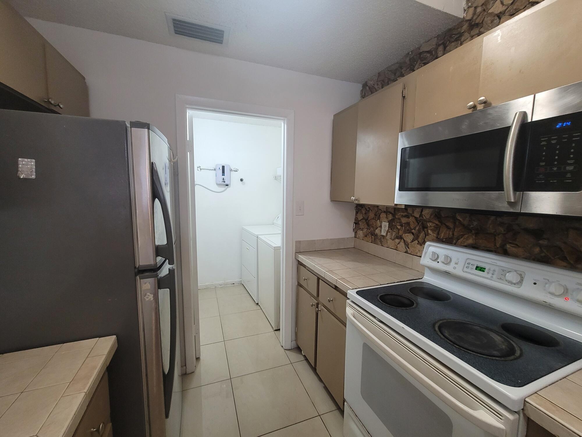 4049 Southwest 68th Way, Unit 6I Miramar, FL 33023 - Photo 12 of 32 a kitchen with a stove and a microwave