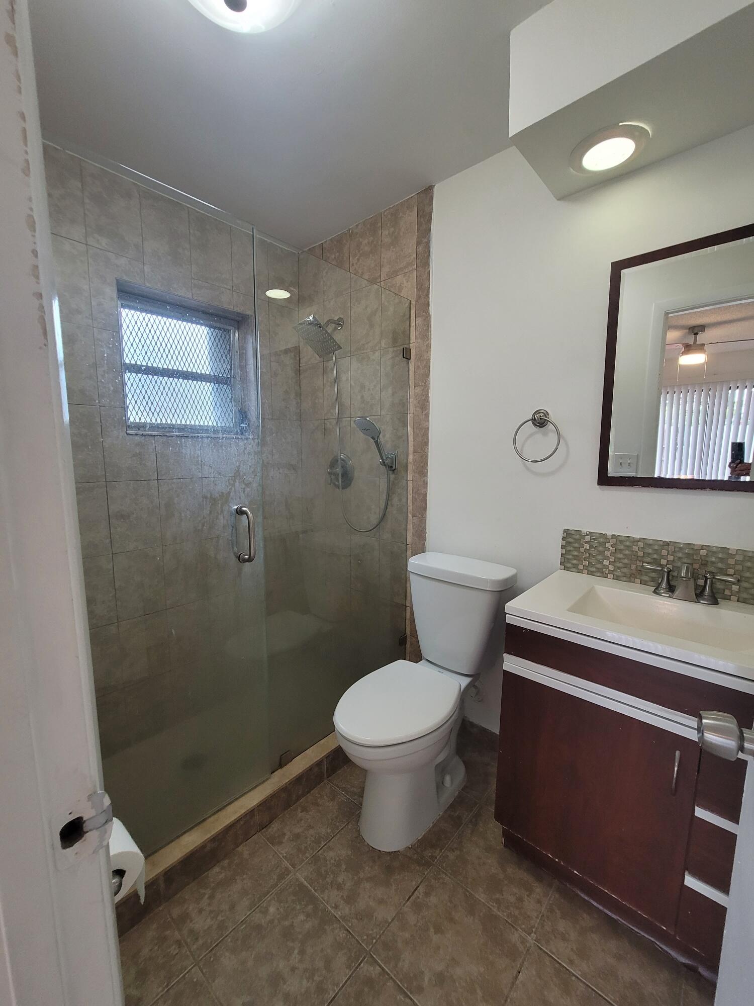 4049 Southwest 68th Way, Unit 6I Miramar, FL 33023 - Photo 21 of 32 a bathroom with a granite countertop toilet a sink and shower