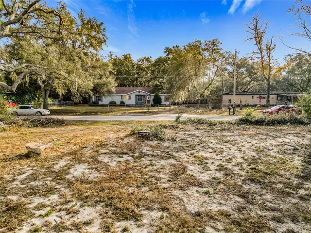 a view of a yard with wooden fence