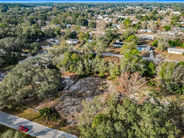 an aerial view of residential house with parking and trees