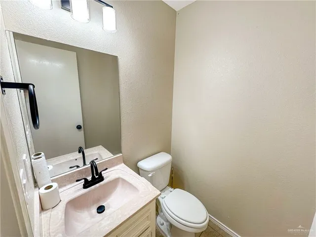 a bathroom with a sink mirror vanity and toilet