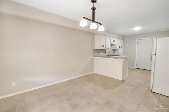 a large kitchen with cabinets and wooden floor
